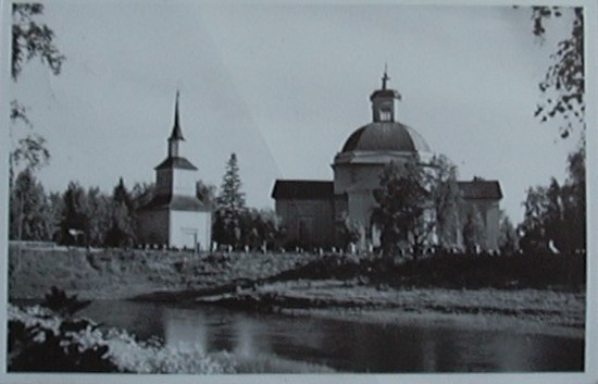Lapua, kirkko ja tapuli, kuva otettu joen takaa.
Kuvan ottanut Albin Aaltonen 1950-luvun lopulla. Postitettu Karstulaan 9.5.59, lÃ¤hettÃ¤jÃ¤ onnittelee jo etukÃ¤teen tulevaa ylioppilasta.
